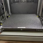 Bề mặt bàn in PEI hoặc kính của máy in 3D Creality K2 Plus giúp tăng độ bám dính và dễ tháo mẫu.