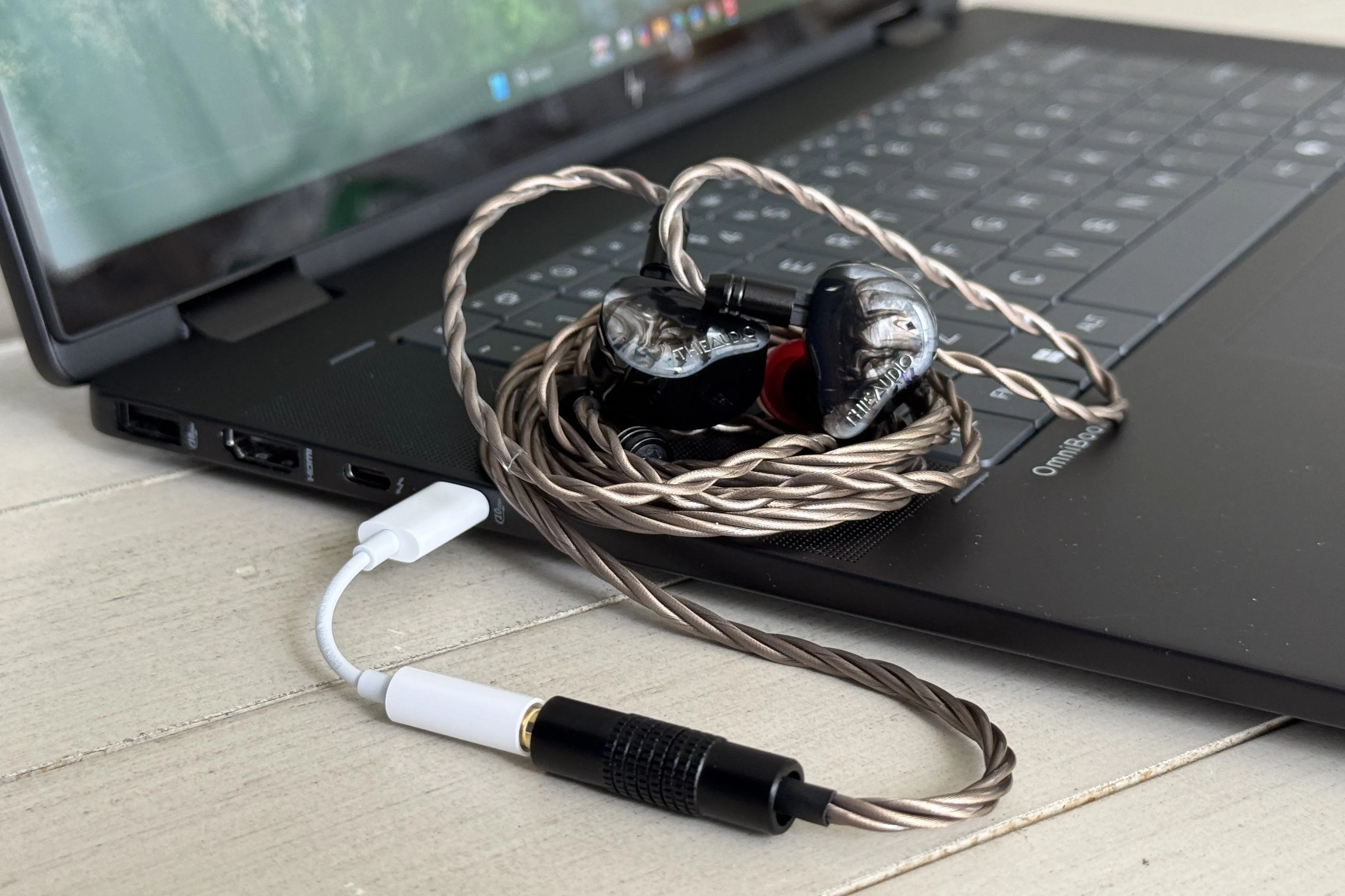 Bộ chuyển đổi Apple USB-C sang 3.5mm đặt cạnh tai nghe IEM cao cấp Moondrop Monarch 2, nhấn mạnh khả năng tương thích với thiết bị đắt tiền