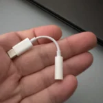 Bộ chuyển đổi Apple USB-C sang 3.5mm nằm gọn trong lòng bàn tay, minh họa kích thước nhỏ gọn