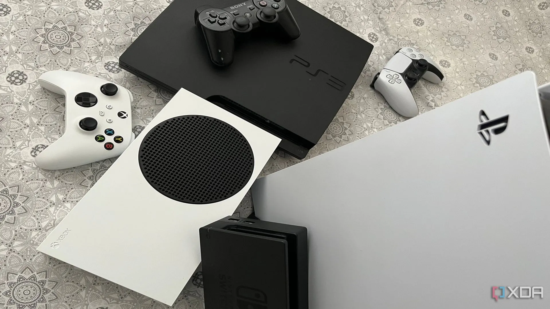 Bộ sưu tập các máy chơi game PlayStation 5, Xbox Series X, dock Nintendo Switch và PlayStation 3 được sắp xếp cùng nhau