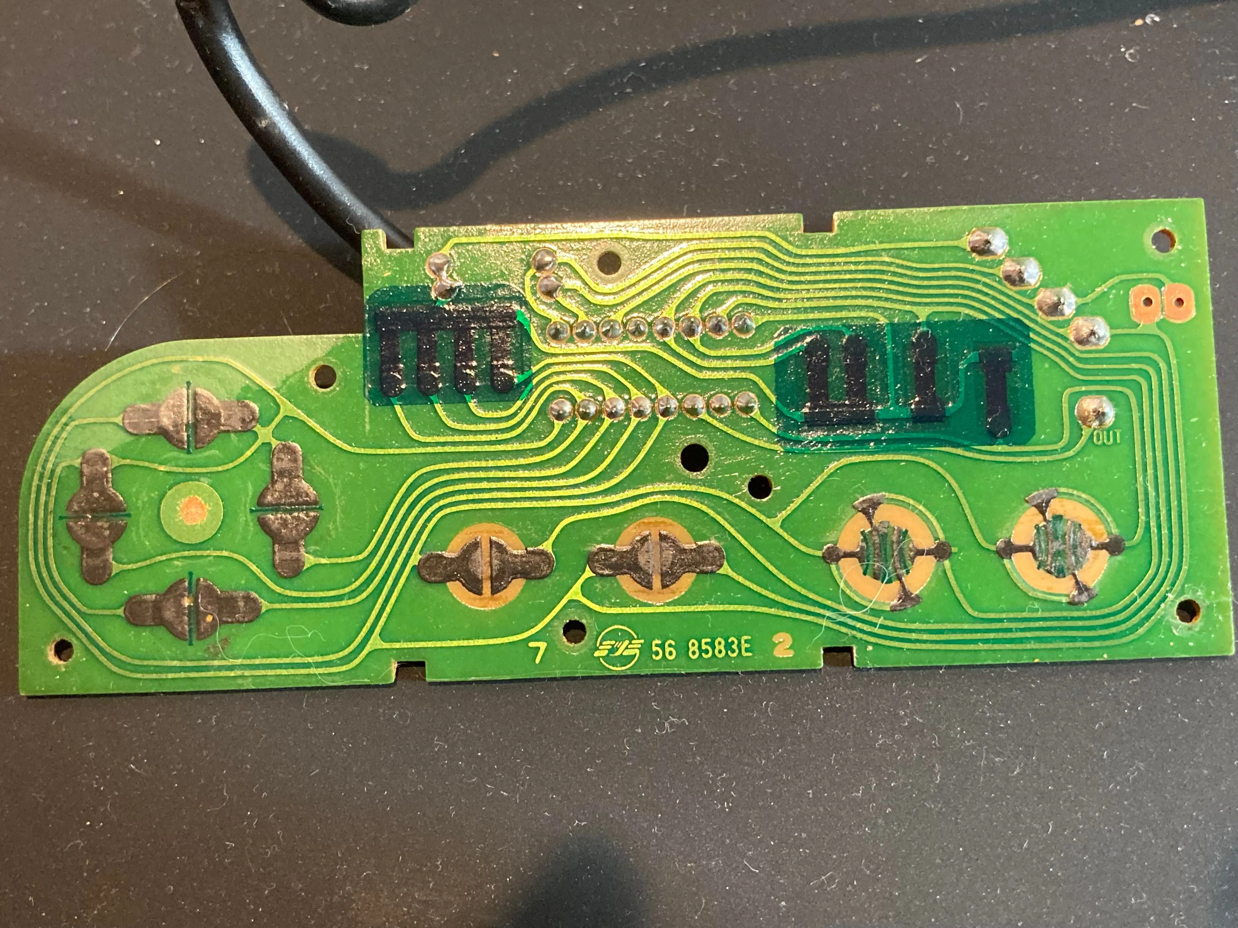 Cận cảnh bảng mạch in (PCB) mặt trước bên trong tay cầm NES, hiển thị các đường mạch và tiếp điểm nút.