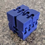 Chiếc fidget cube (infinity cube) màu đen, một loại đồ chơi 3D in phổ biến giúp giảm căng thẳng.