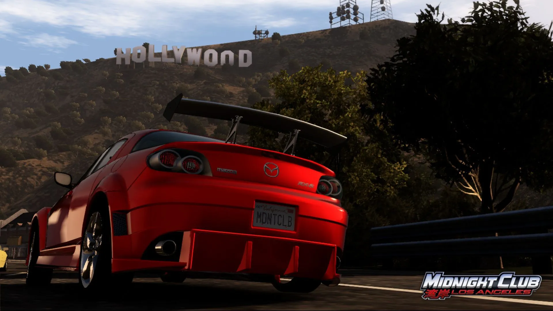 Chiếc Mazda RX-7 màu cam trong Midnight Club: Los Angeles trên đường phố với biển hiệu Hollywood phía sau, minh họa cho sự đa dạng game đua xe mà Rockstar có thể mang lại.