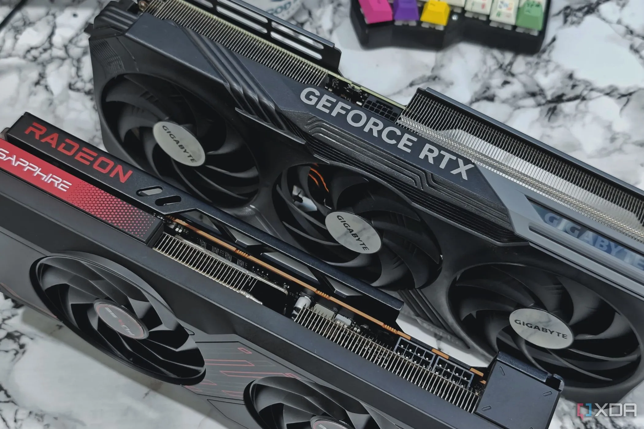 Hai card đồ họa hiện đại Nvidia GeForce RTX 4070 Ti và AMD Radeon 7700XT đặt trên bàn, thể hiện sự phát triển của hiệu năng GPU đơn