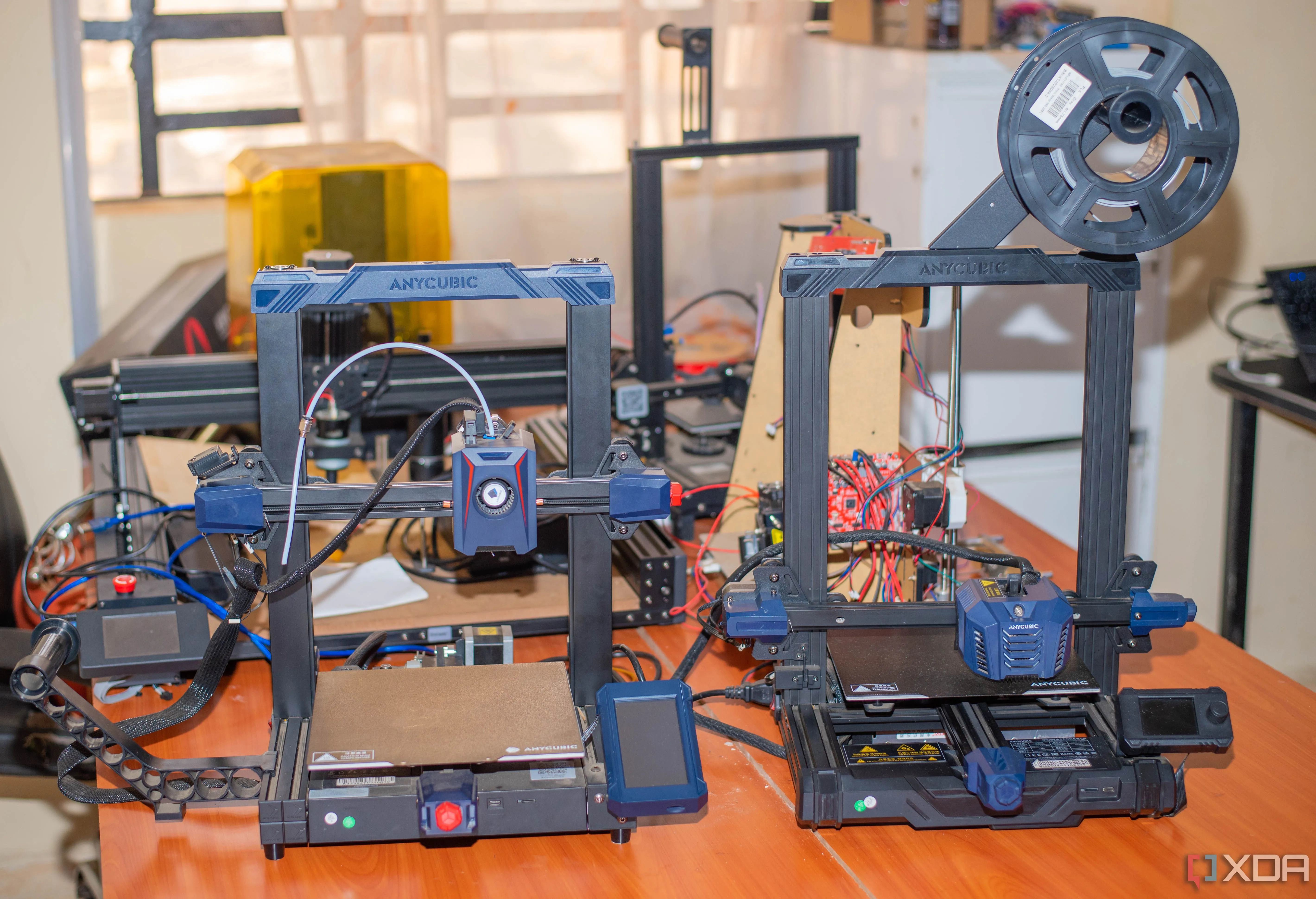 Hai máy in 3D đặt trên bàn làm việc, biểu tượng cho sự cải tiến và nâng cấp công nghệ in 3D.