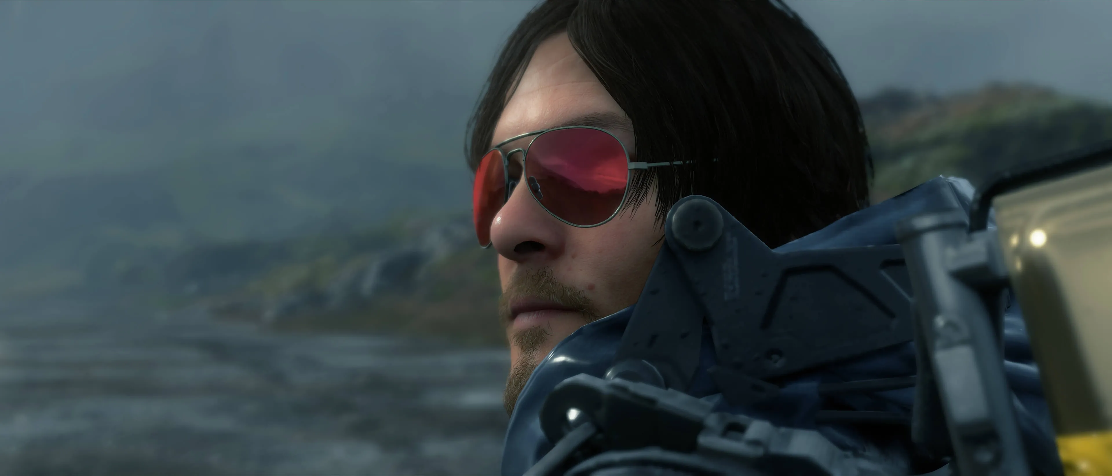 Hình ảnh nhân vật Sam Bridges trong game Death Stranding đeo kính râm, chuẩn bị cho chuyến giao hàng đầy thử thách.