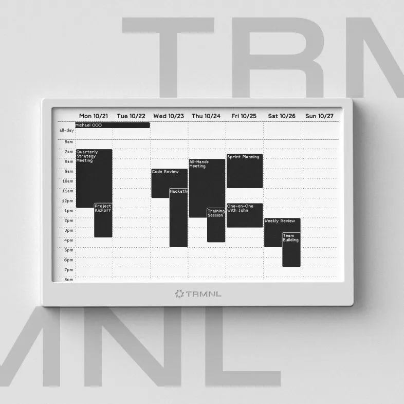 Màn hình ePaper TRMNL nhỏ gọn đặt trên bàn làm việc, làm dashboard thông tin phụ bên cạnh laptop và màn hình chính.