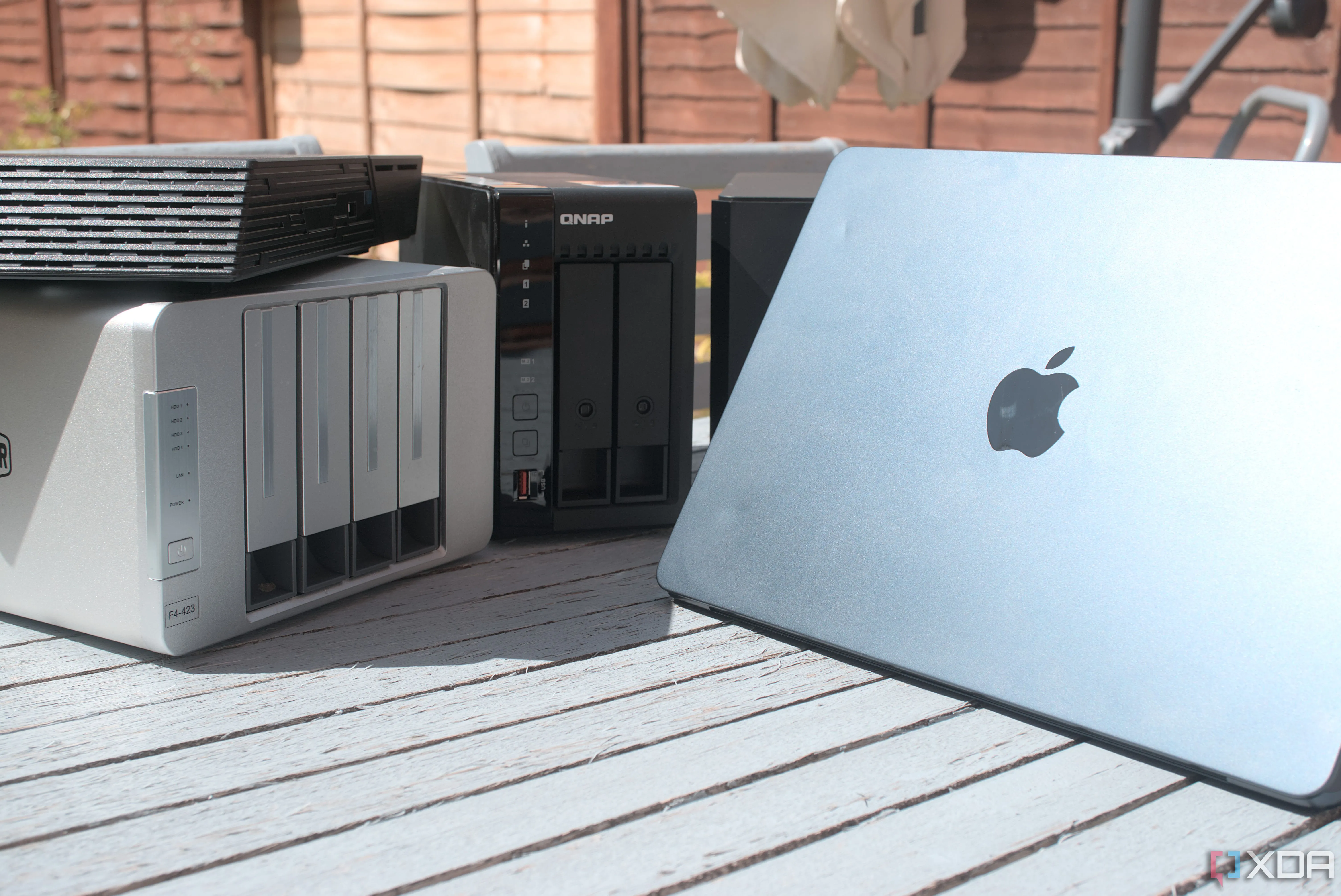 Máy tính MacBook Air kết nối không dây với thiết bị NAS, tượng trưng cho việc sao lưu dữ liệu laptop tự động qua mạng.