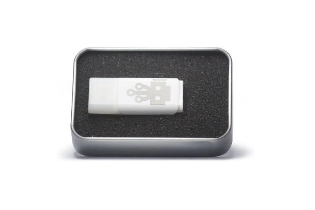 Một chiếc USB nhỏ màu trắng được đặt trên một vỏ hộp màu đen, thể hiện tính nguy hiểm của thiết bị