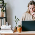 Người phụ nữ trầm tư nhìn màn hình laptop khi thấy cảnh báo virus