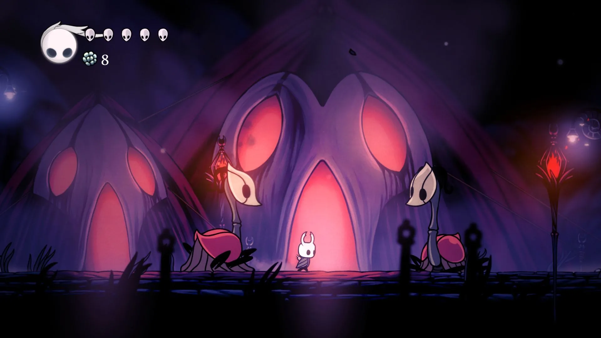 Nhân vật Hollow Knight đứng giữa hai quái vật trong game, biểu tượng của một tựa game platformer kinh điển có ảnh hưởng lớn đến ngành công nghiệp game.