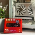 Ổ cứng SSD XPG Gammix S70 Blade 2TB trên hộp sản phẩm, gần chậu cây giả và vỏ case máy tính