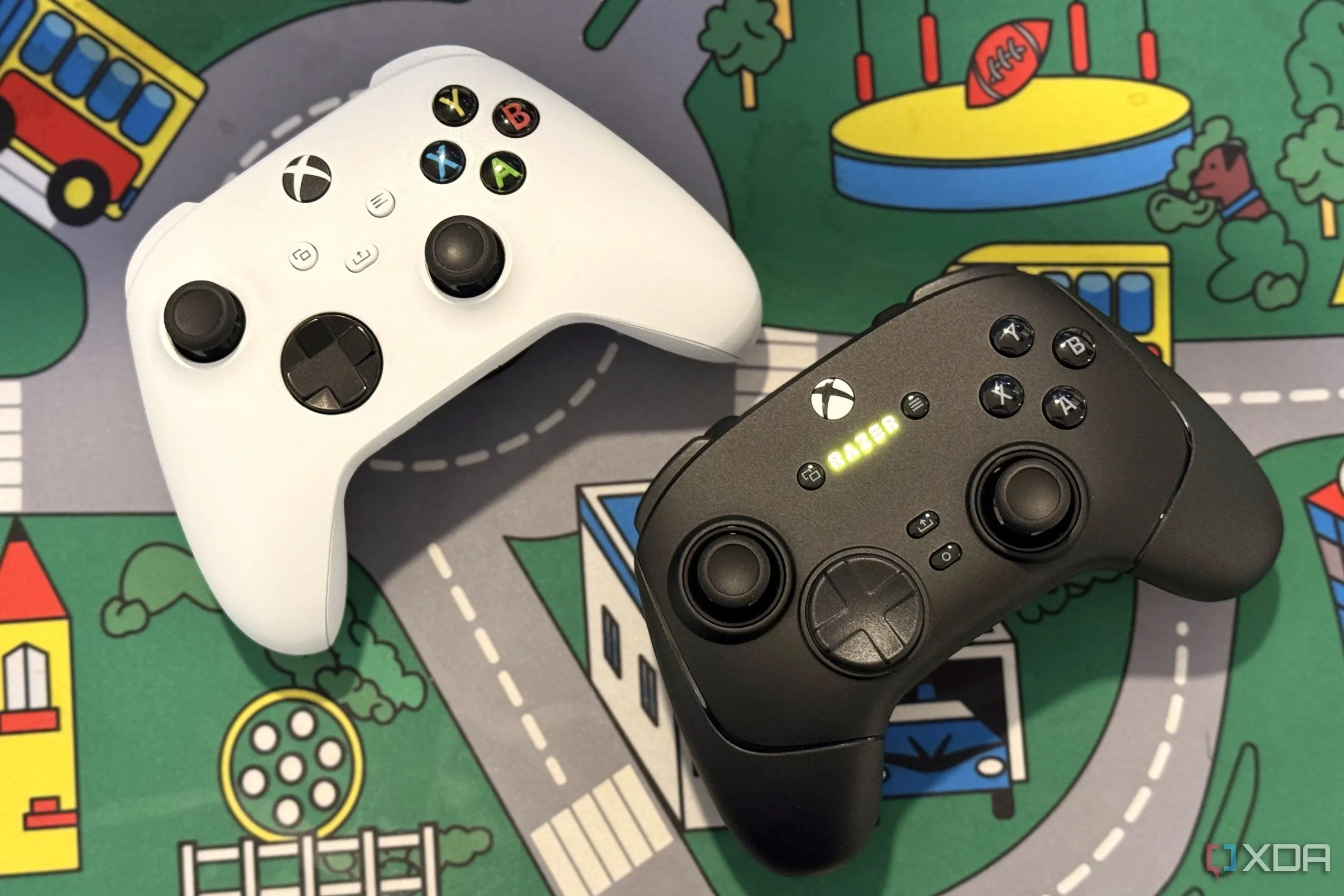 Tay cầm chơi game Razer Wolverine V3 Pro đặt cạnh tay cầm Xbox màu trắng trên bàn.